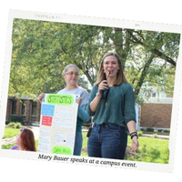 Mary Bauer, a woman with blonde hair in a green shirt and blue jeans, speaks at a campus event.