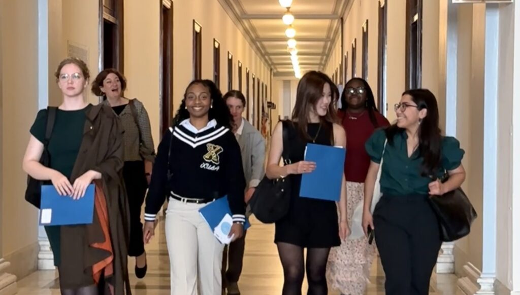 Group of seven women walking down the Halls of Congress